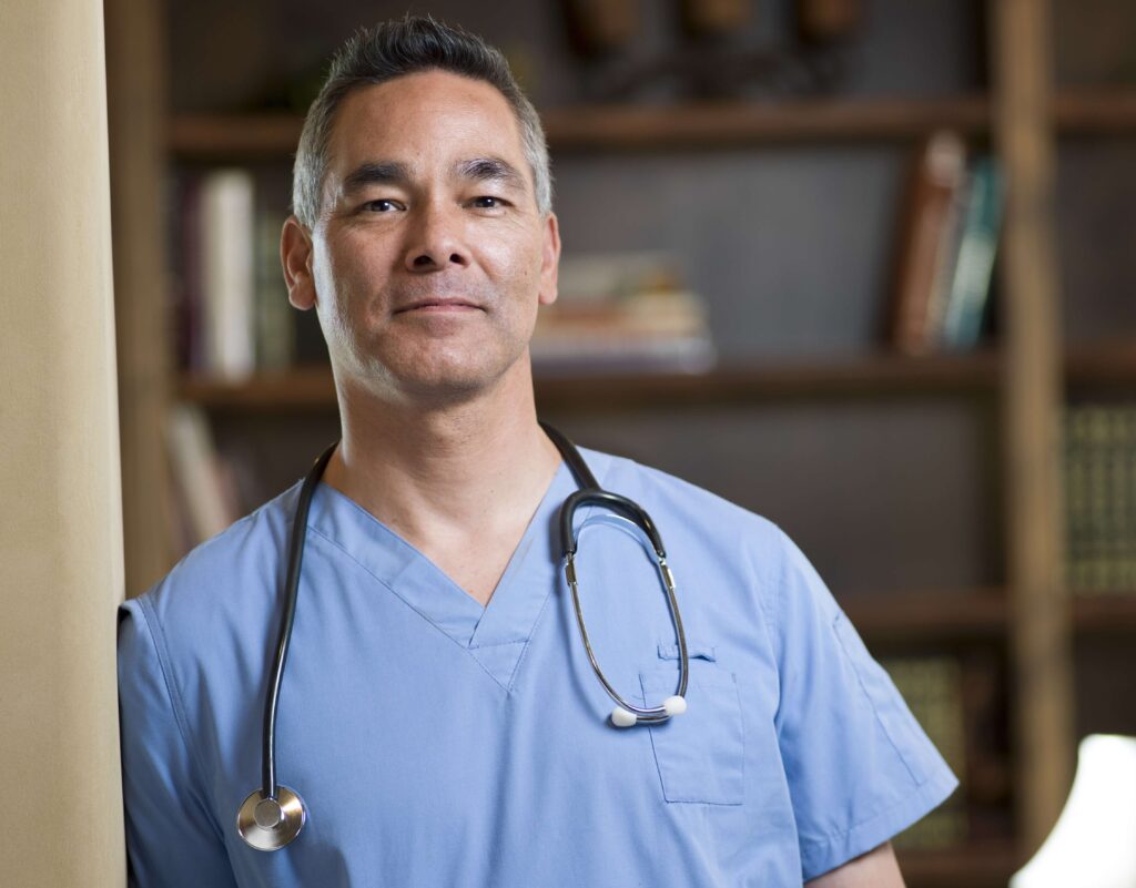 Doctor with stethoscope leaning in doorway